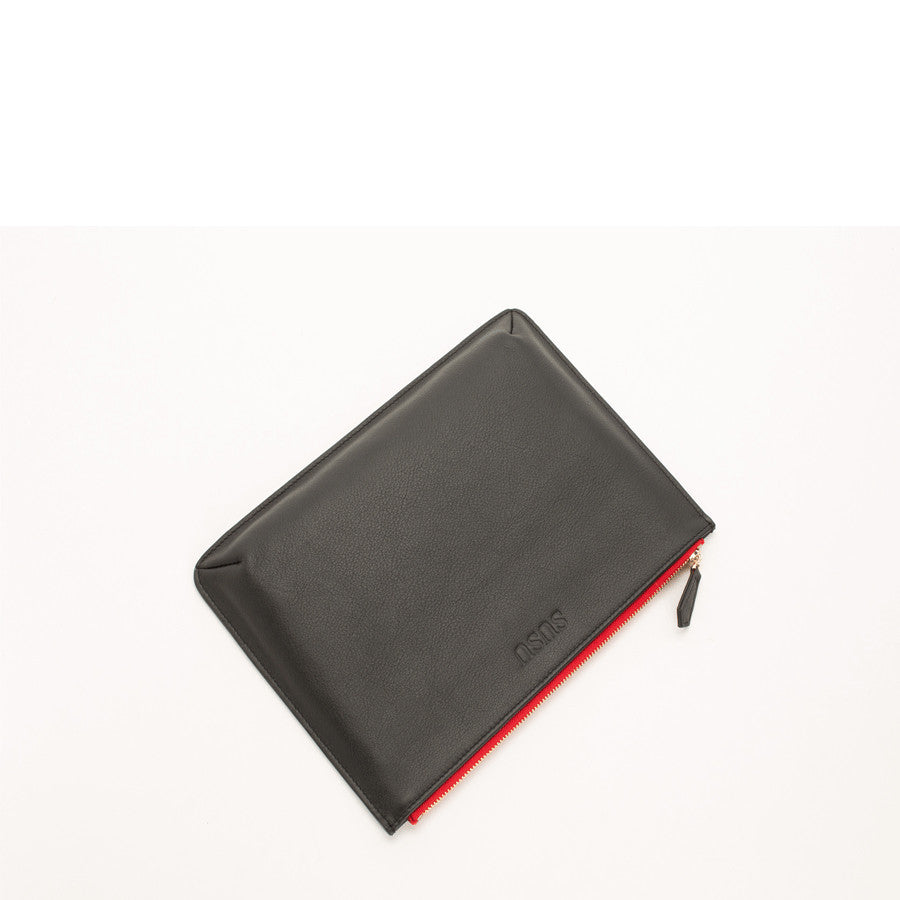 Elegant black pebbled leather clutch case for iPad with vibrant red zipper detail by SUSU.