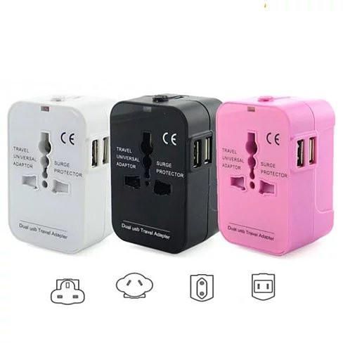 Worldwide power adapter and travel charger with dual USB ports, available in pink, black, and white.